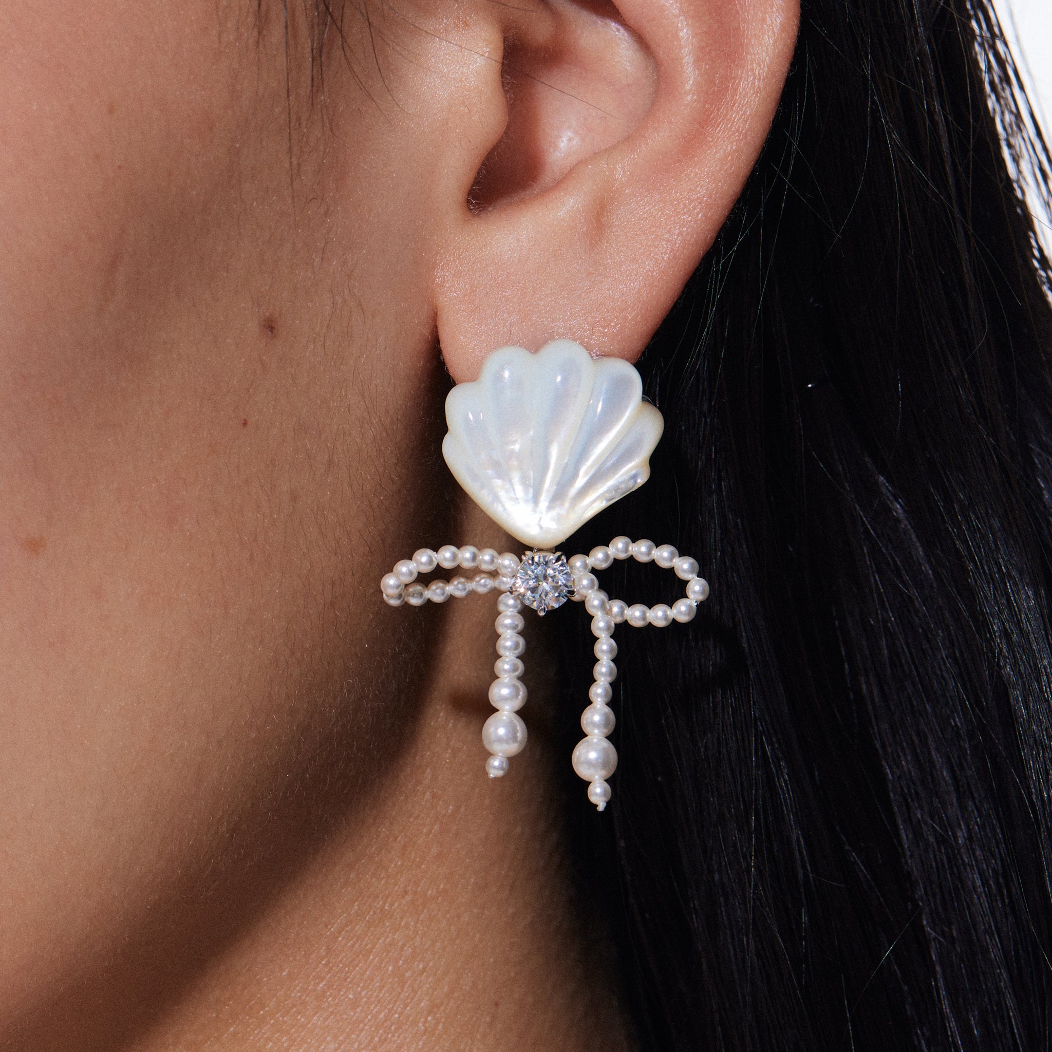 YVMIN carved shell pearl bow stud earrings featuring island-inspired design and intricate pearl carving on silver-tone metal.
