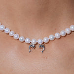 YVMIN Island double dolphin pearl necklace featuring a silver chain with two dolphin charms and a central pearl.
