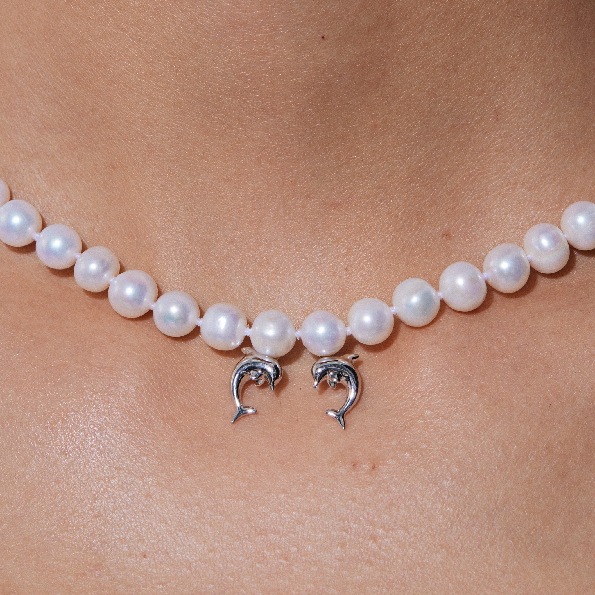 YVMIN Island double dolphin pearl necklace featuring a silver chain with two dolphin charms and a central pearl.