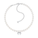 YVMIN Island double dolphin pearl necklace featuring a gold chain and two dolphin charms with pearl accents.